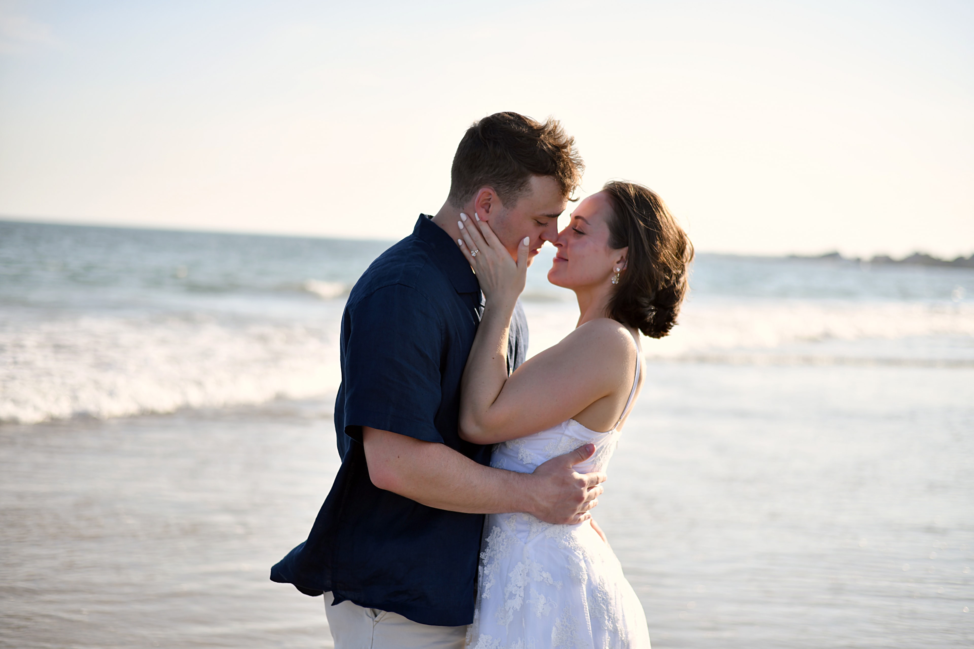 Couple kissing on the beach at sunset
