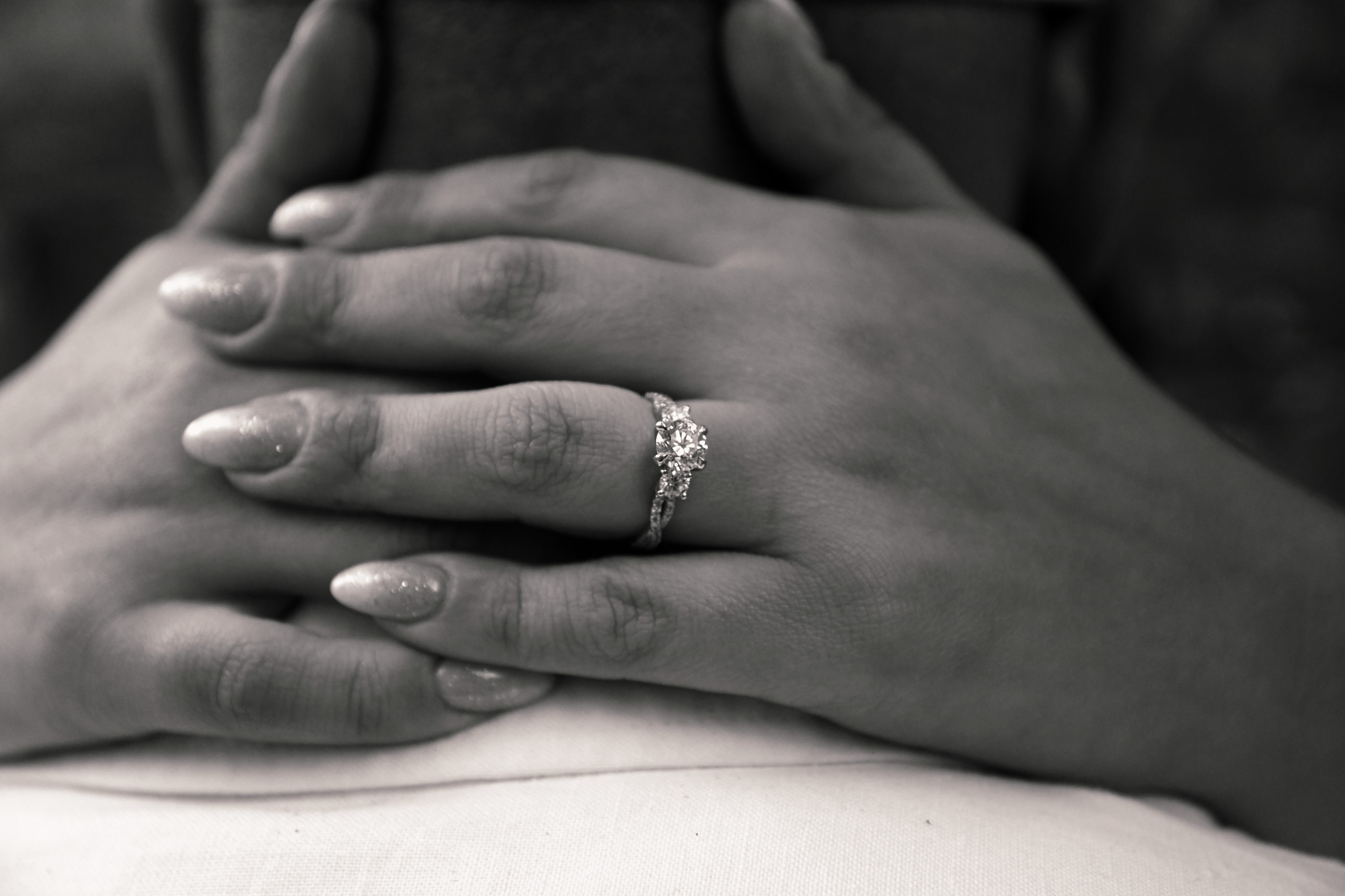 Couple's hands with diamond engagement ring