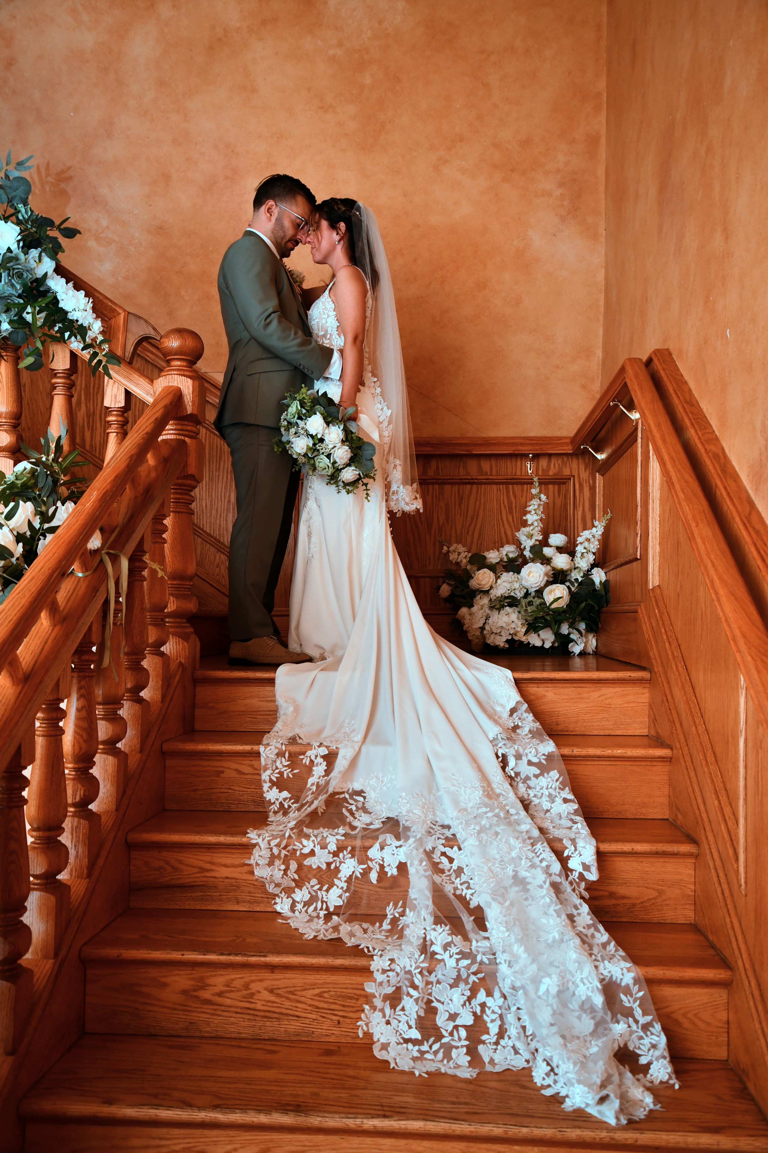 Bride and groom forehead to forehead on staircase