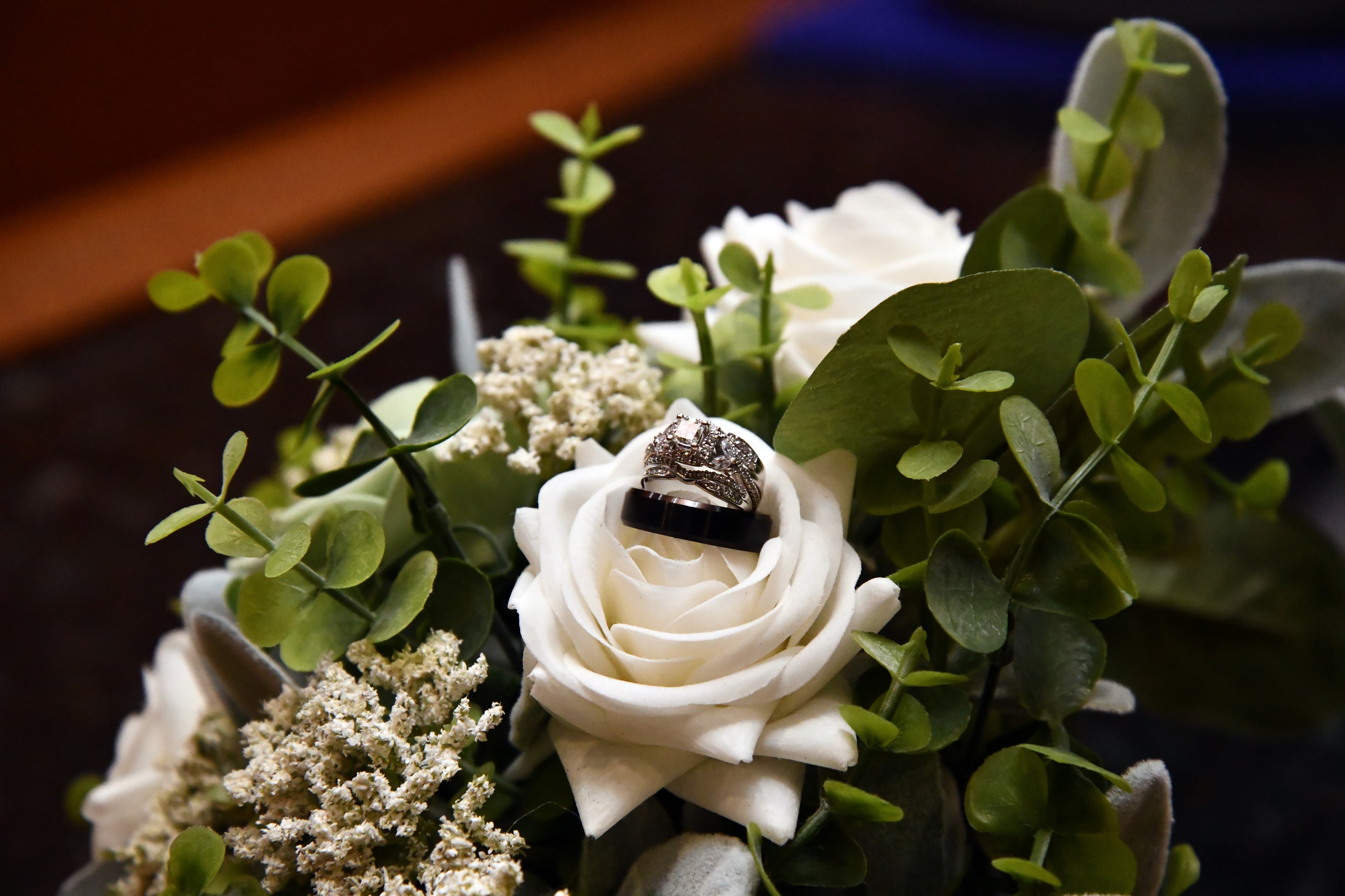 Wedding rings nestled in white rose bouquet