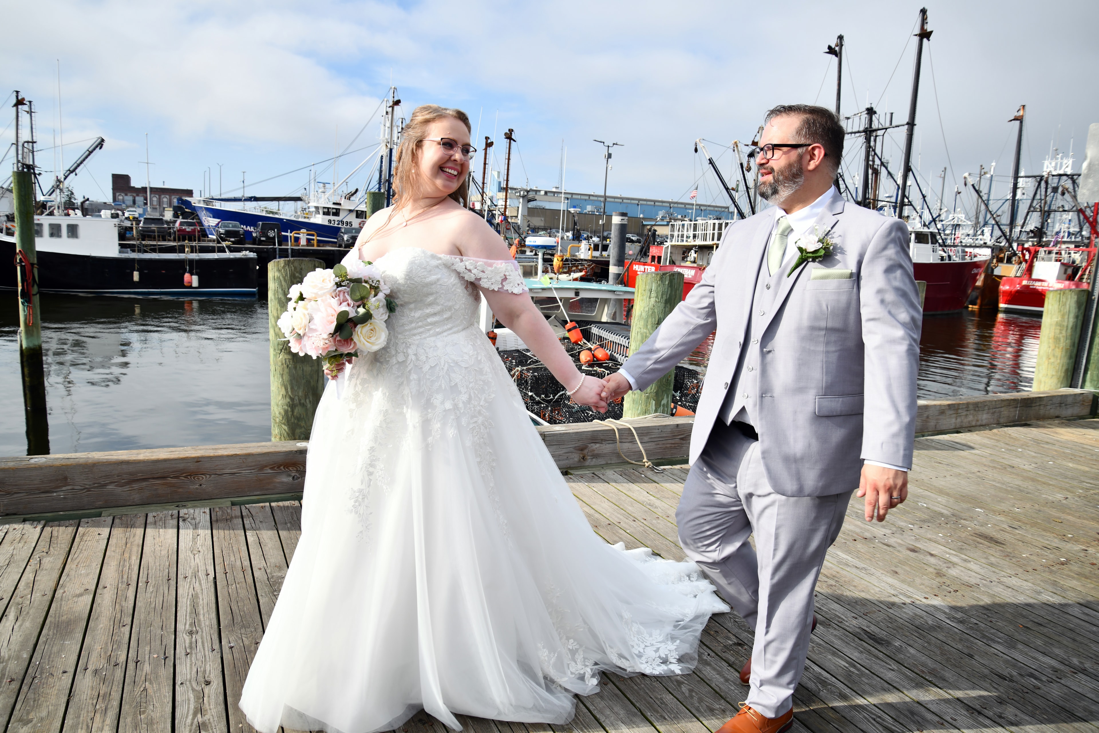 Bride and groom laughing on harbor dock
