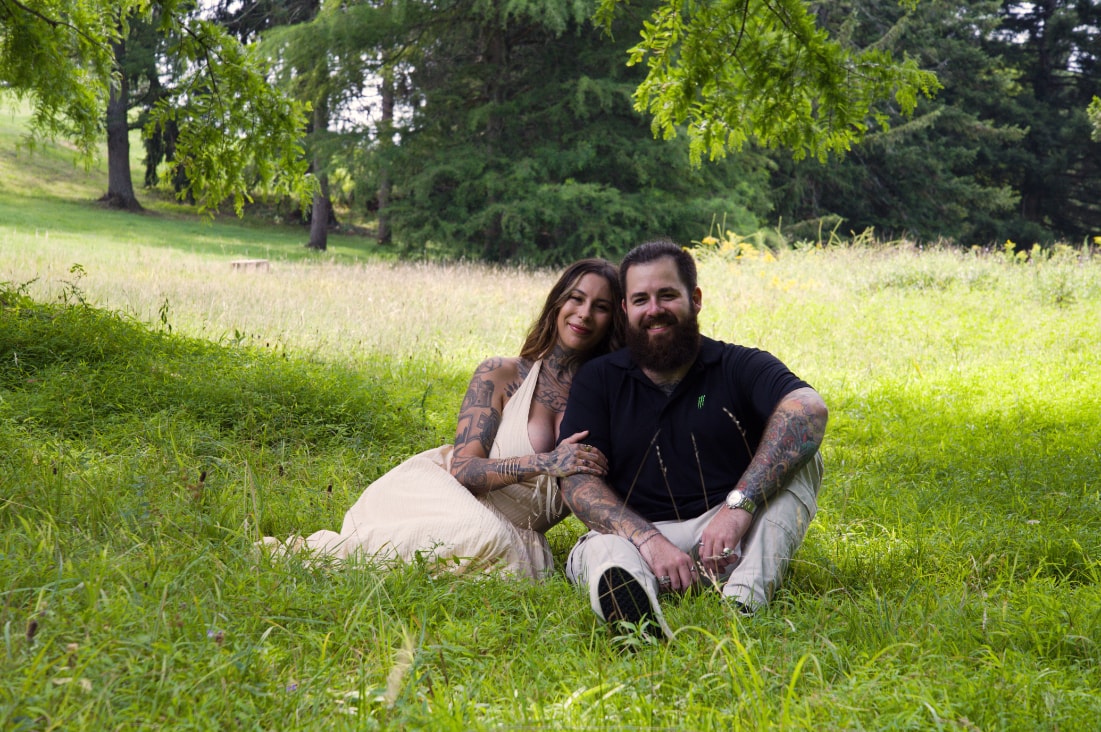 Couple sitting in a sunny meadow smiling together