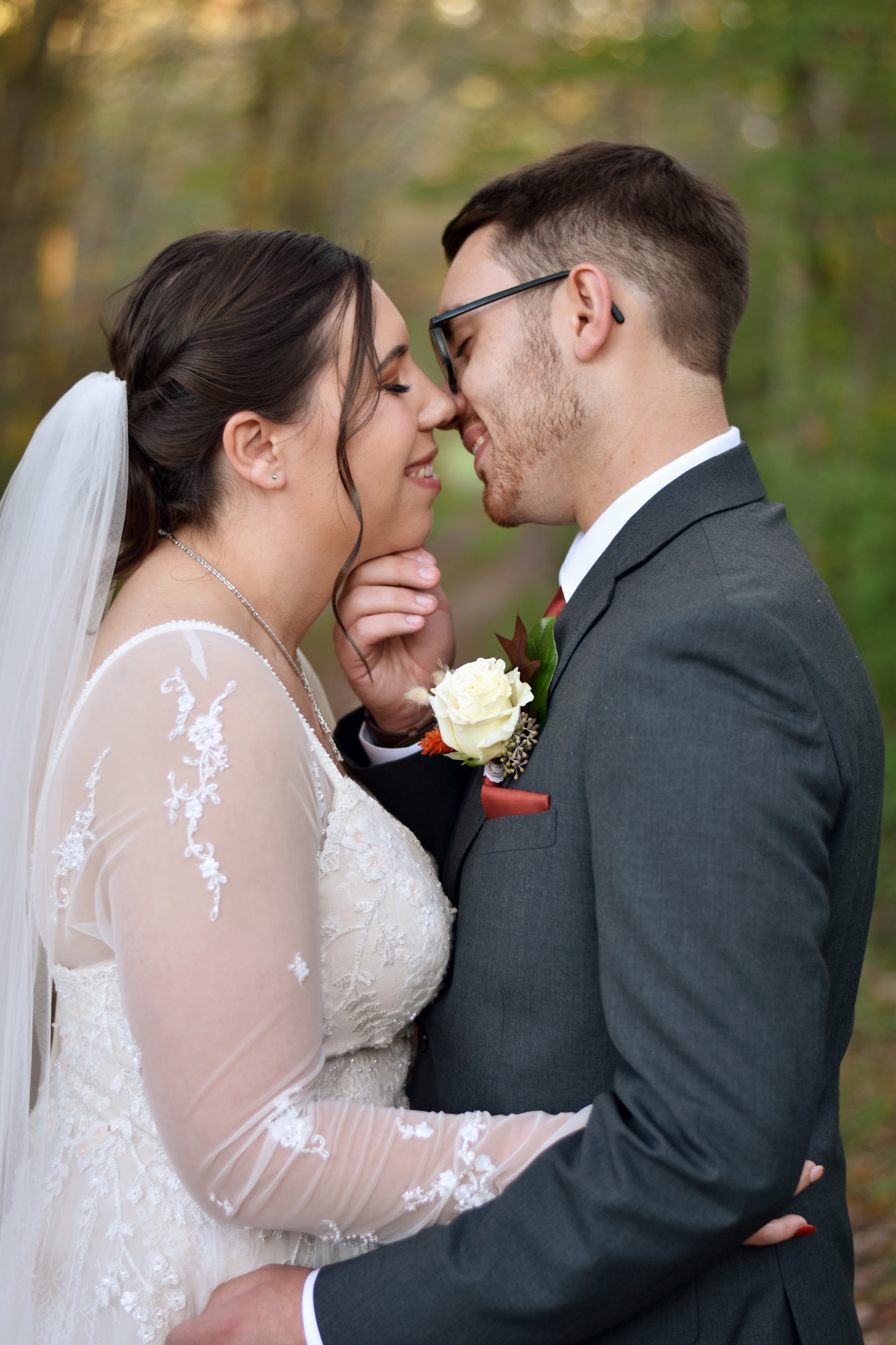 Bride and groom nose to nose laughing in autumn forest