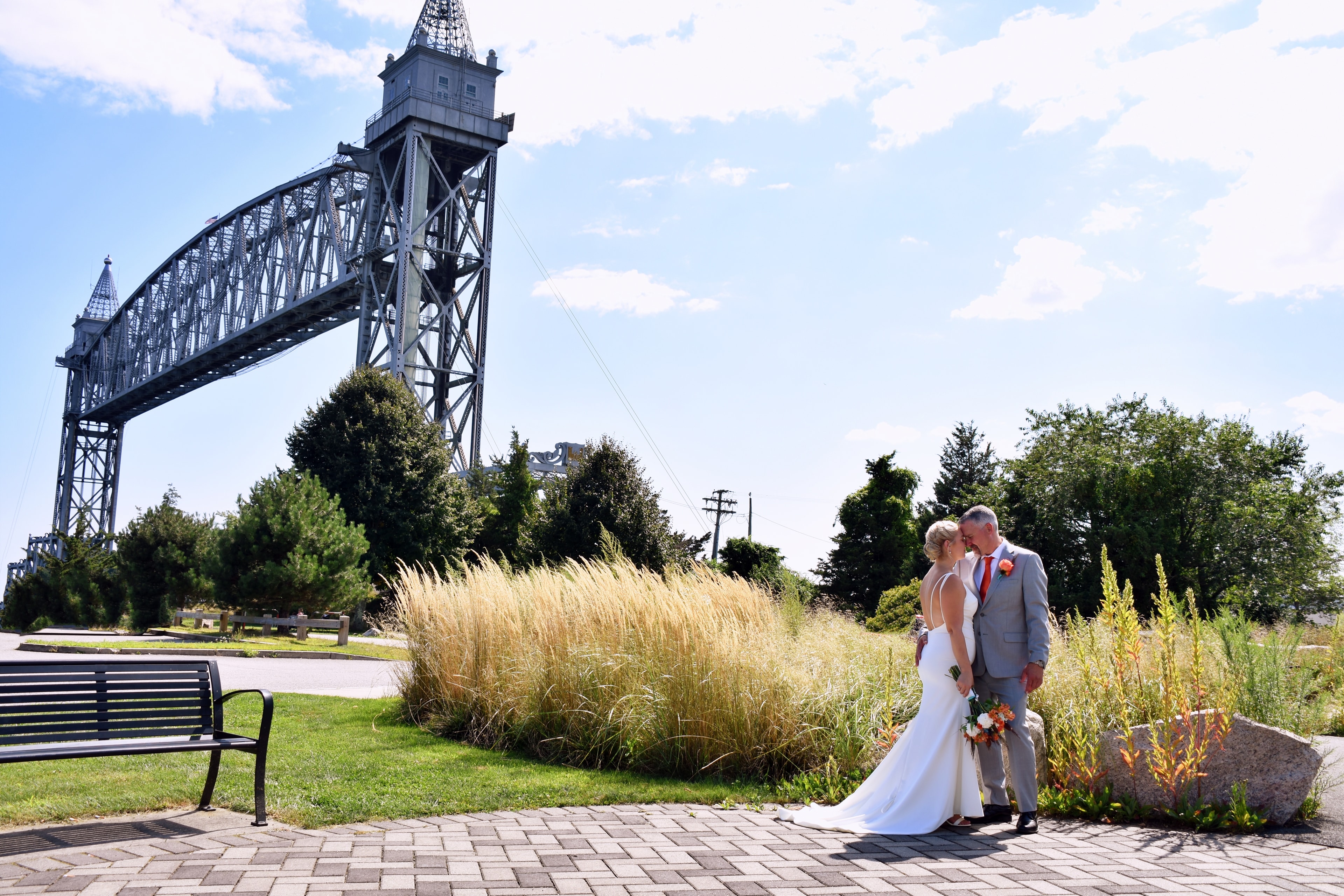Bride and groom kissing near Cape Cod Canal railroad bridge