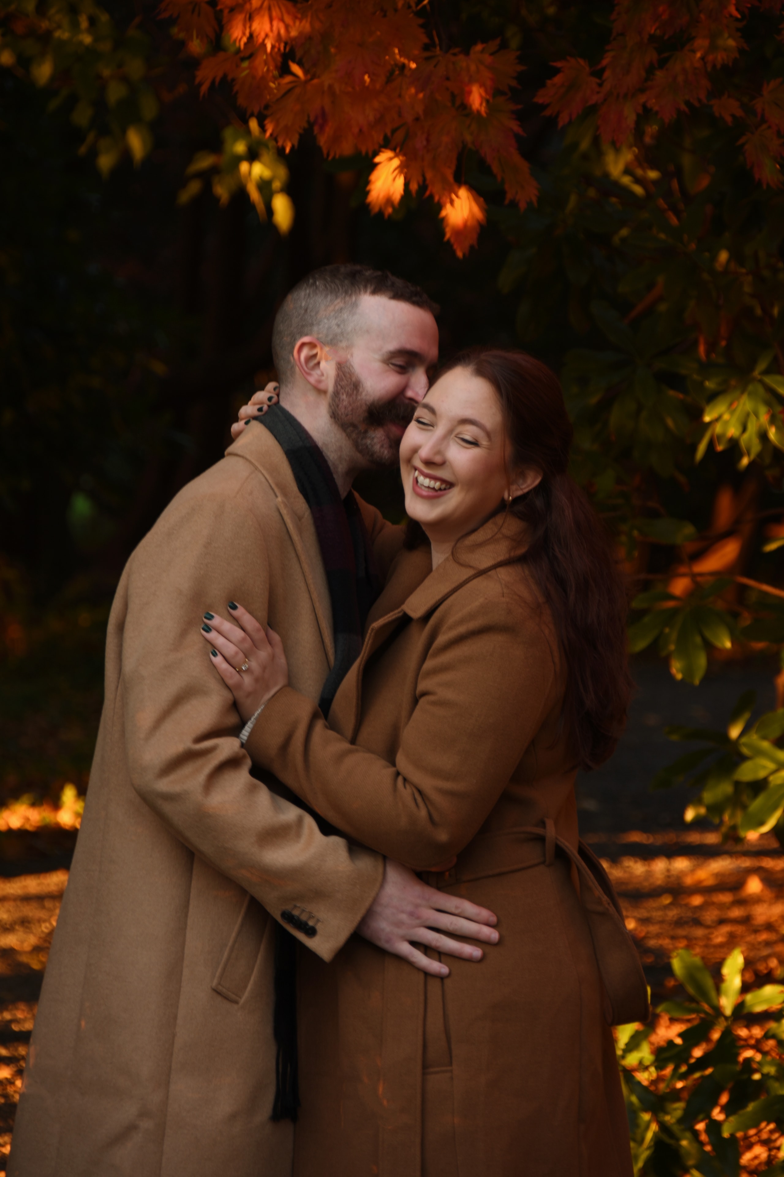 Couple embracing under autumn foliage