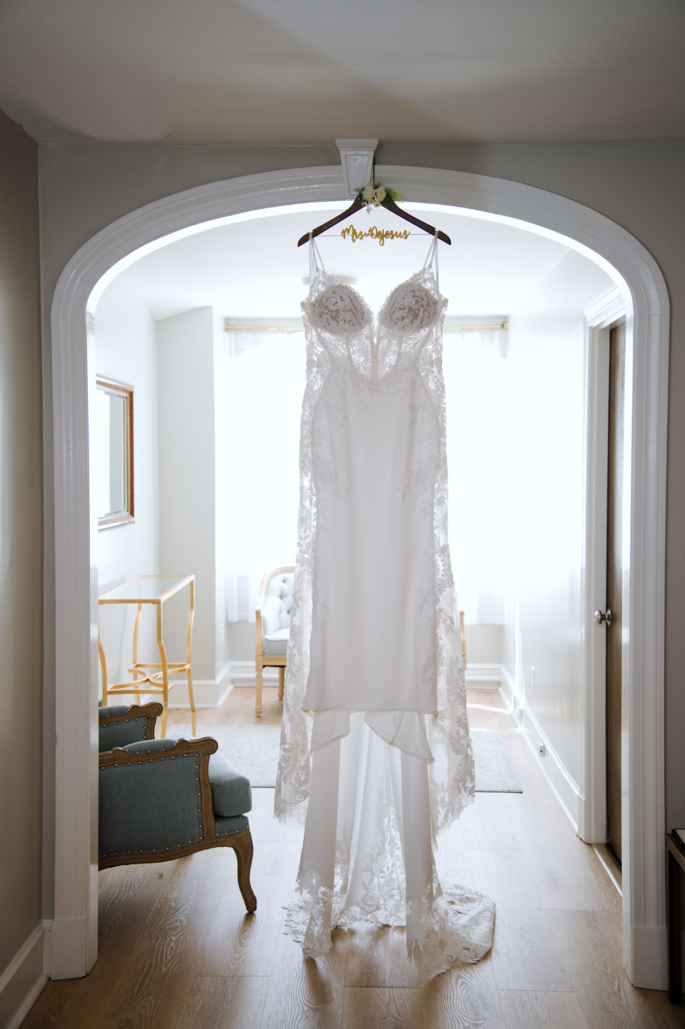 Wedding dress hanging in arched doorway on personalized hanger